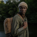 Man carrying Eden waxed canvas and leather backpack on one shoulder