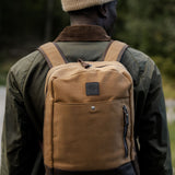 Man wearing tan waxed canvas and leather backpack