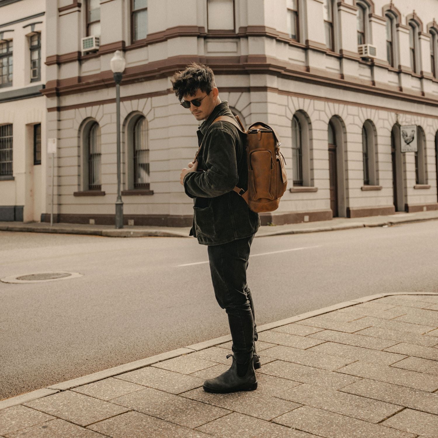 Man in street wearing reclaimed leather tan backpack