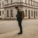 Man in street wearing reclaimed leather tan backpack