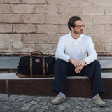 Man sat on outdoor seating with the Humber waxed canvas holdall next to him.