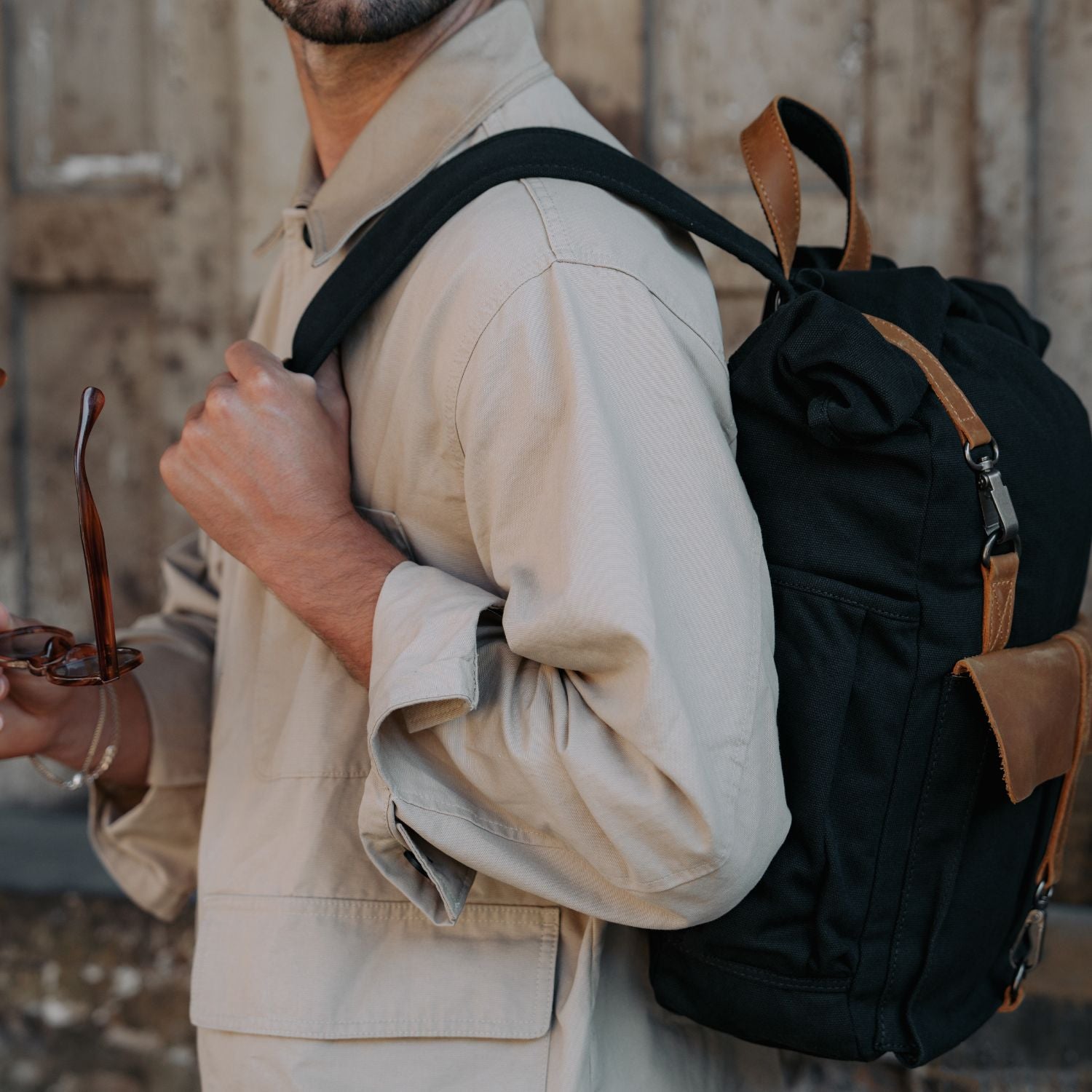 Man wearing the Tay canvas backpack over one shoulder