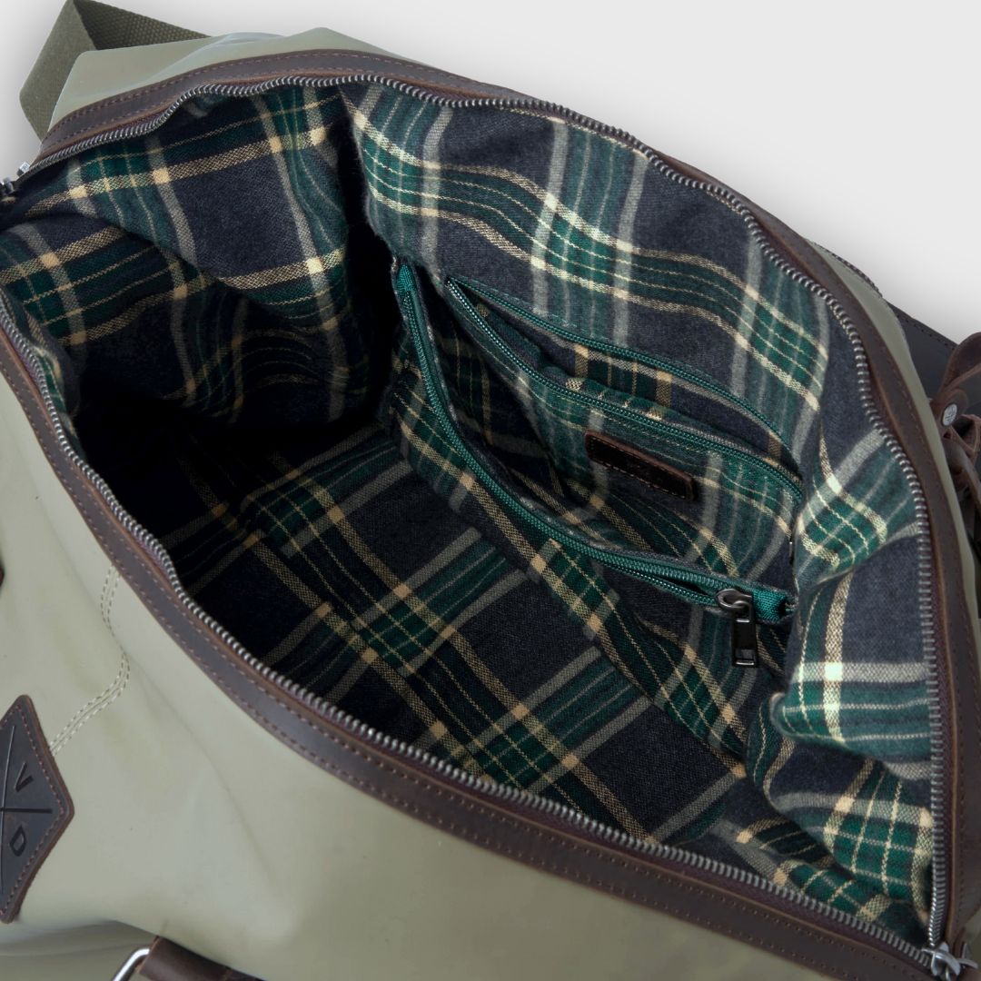 Close-up of a plaid interior lining of a bag with visible stitching.