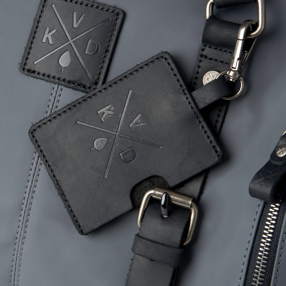 Black leather strap with metal buckle on a gray background