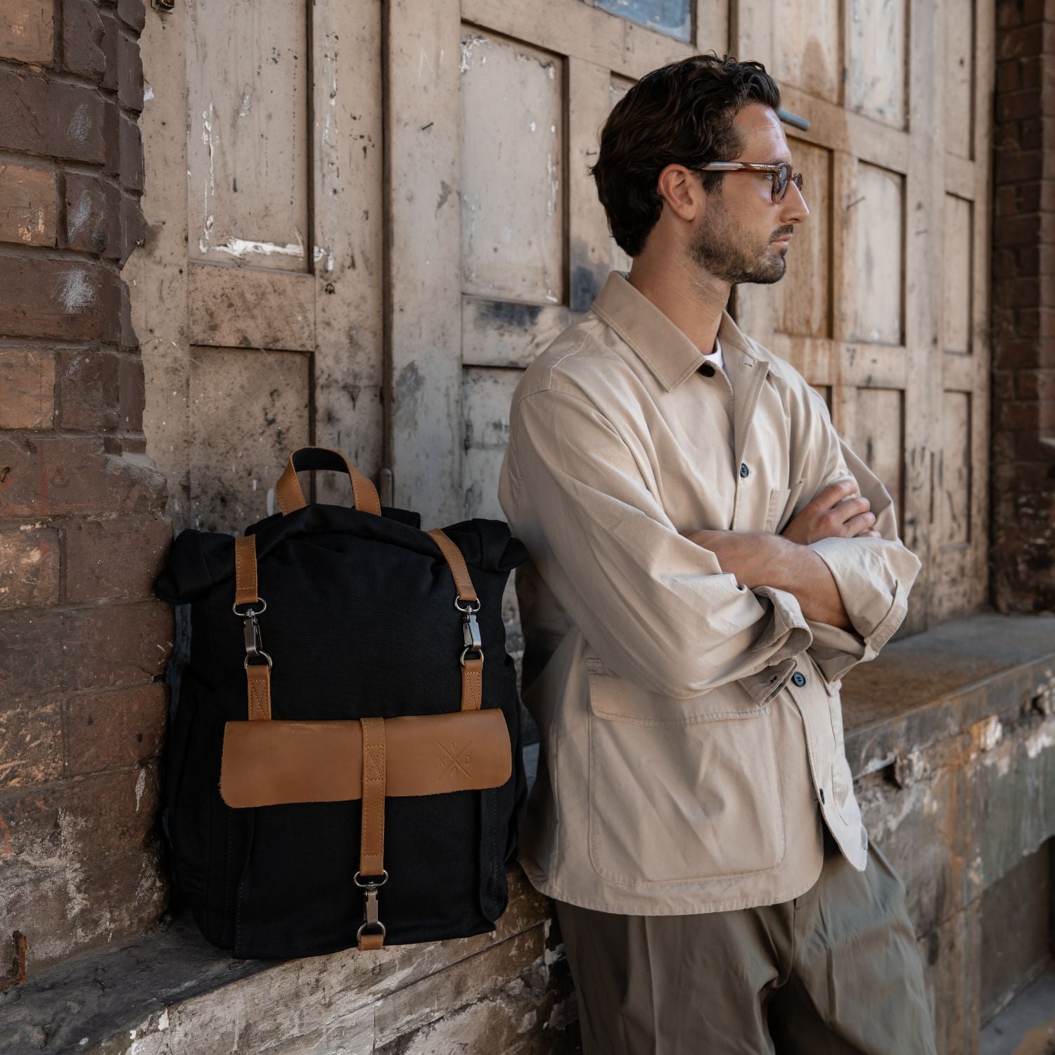 Man stood next to the Tay canvas and reclaimed leather backpack