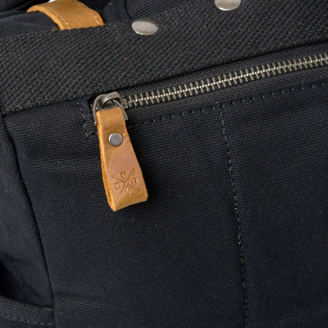 Kovered branded leather zip pull on the waxed canvas Tay rolltop backpack.
