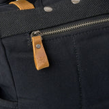 Kovered branded leather zip pull on the waxed canvas Tay rolltop backpack.