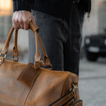 Man carrying tan leather winster holdall with carry handles