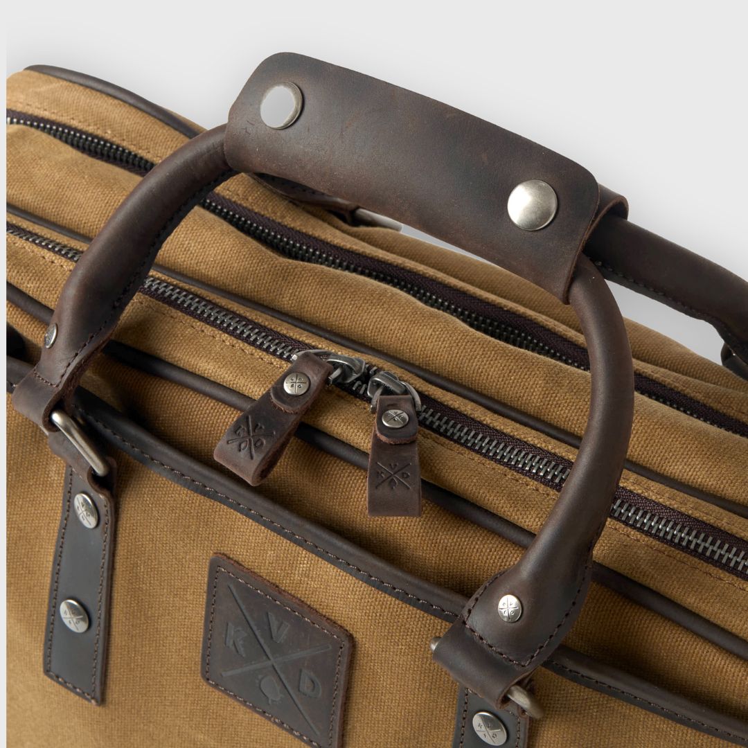Brown leather suitcase with handles and zippers on a white background