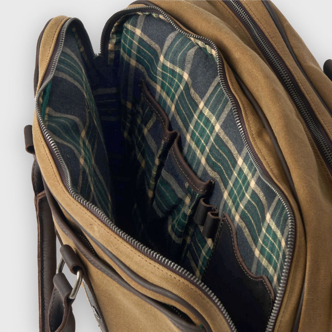 Brown leather bag with plaid interior on a white background