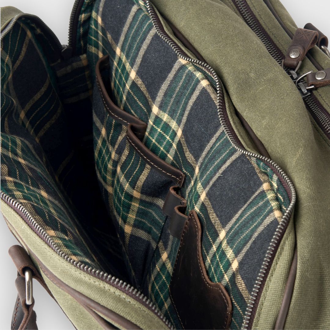 Green plaid fabric inside a green bag with brown leather accents.
