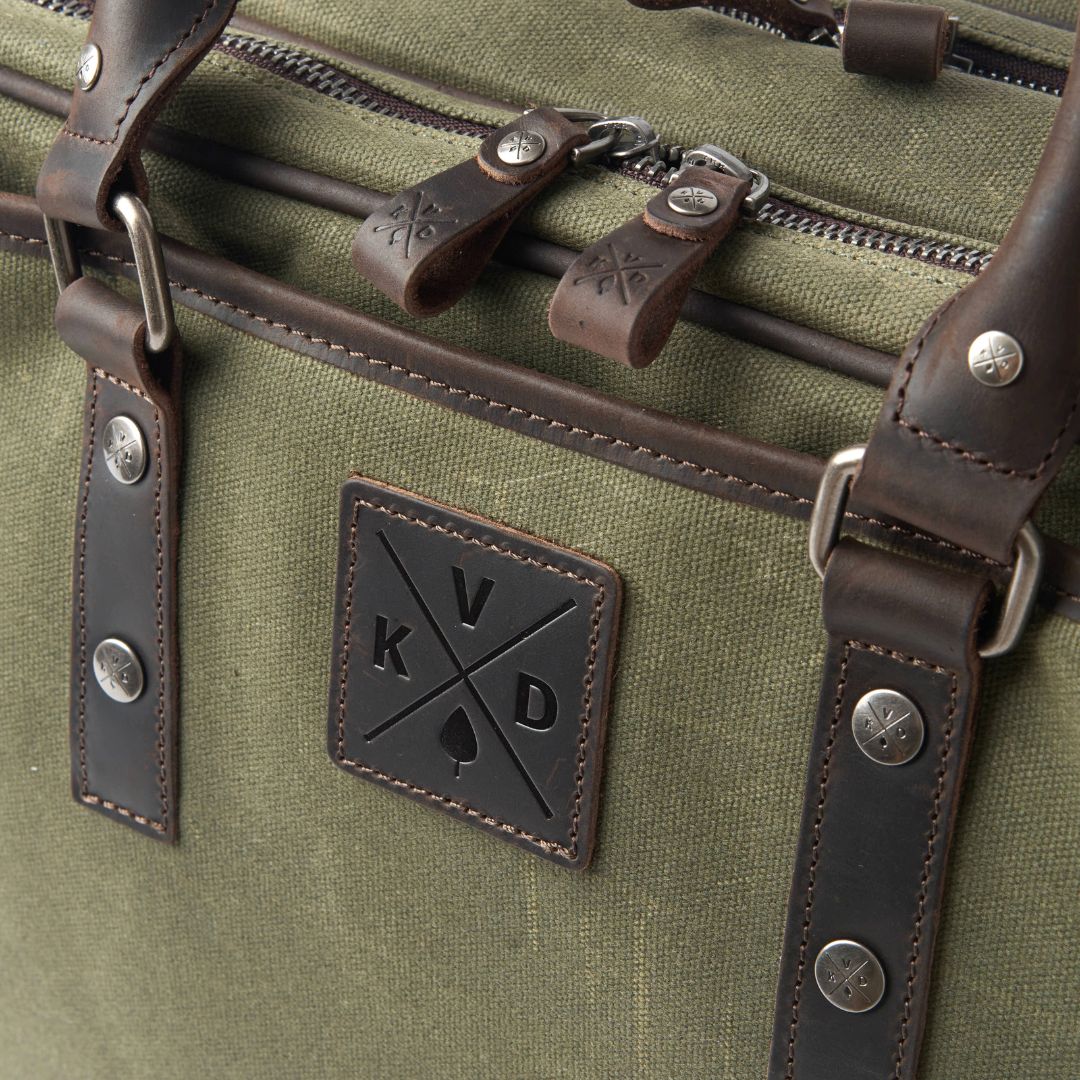 Green bag with leather straps and a brand logo on a green background