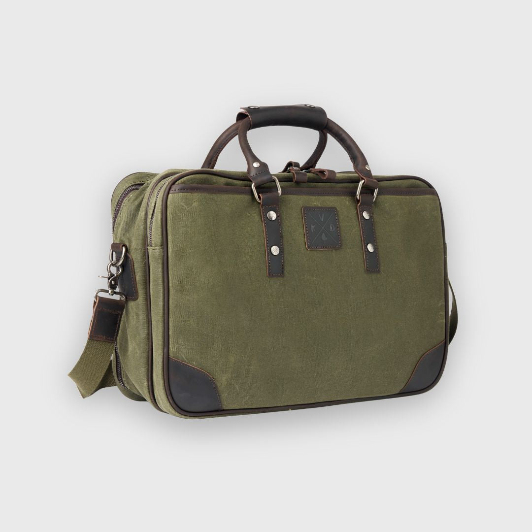 Green travel bag with brown handle and strap on a light gray background
