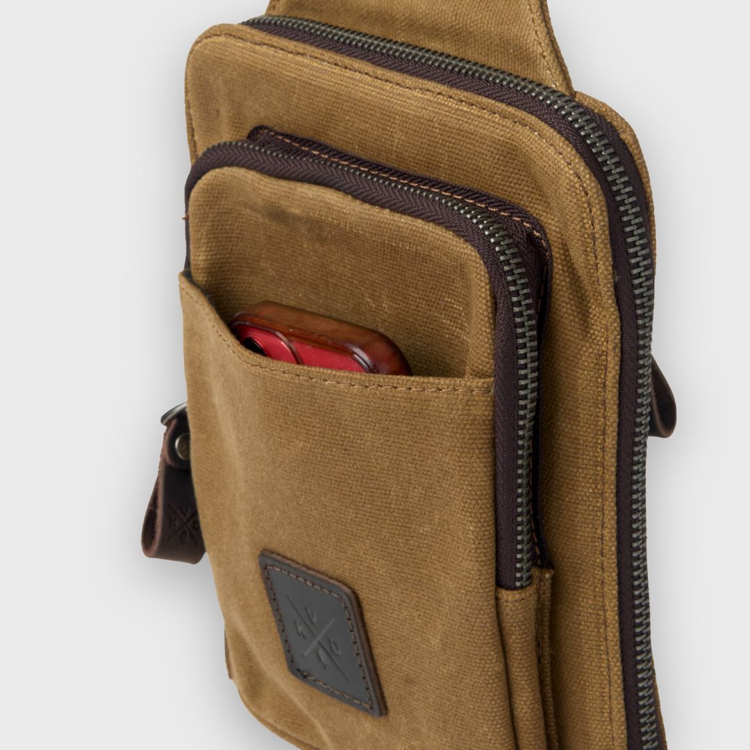 Brown leather crossbody bag with a visible brand logo on a white background