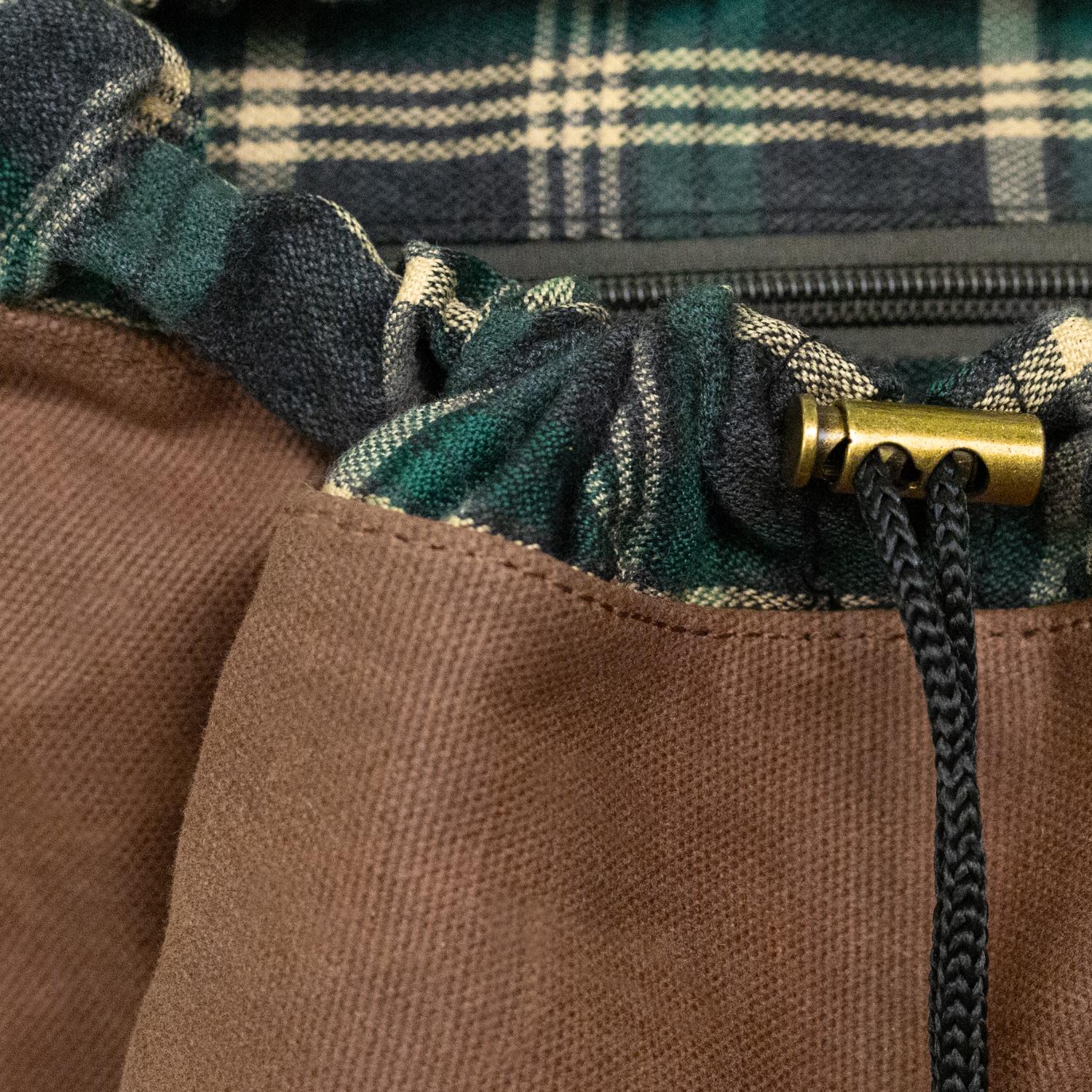 Drawstring closure and brass toggle on the Lune Backpack.