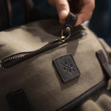 Close up image of the zipped pocket on the top flap of the Lune Backpack