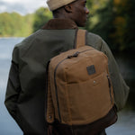 Man wearing Eden waxed canvas and leather backpack over one shoulder