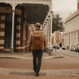 Man walking down the street wearing Esk reclaimed leather weekend backpack in Tan