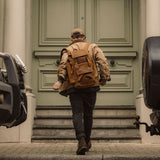 Man standing in front of large door wearing Esk - Tan reclaimed leather backpack 