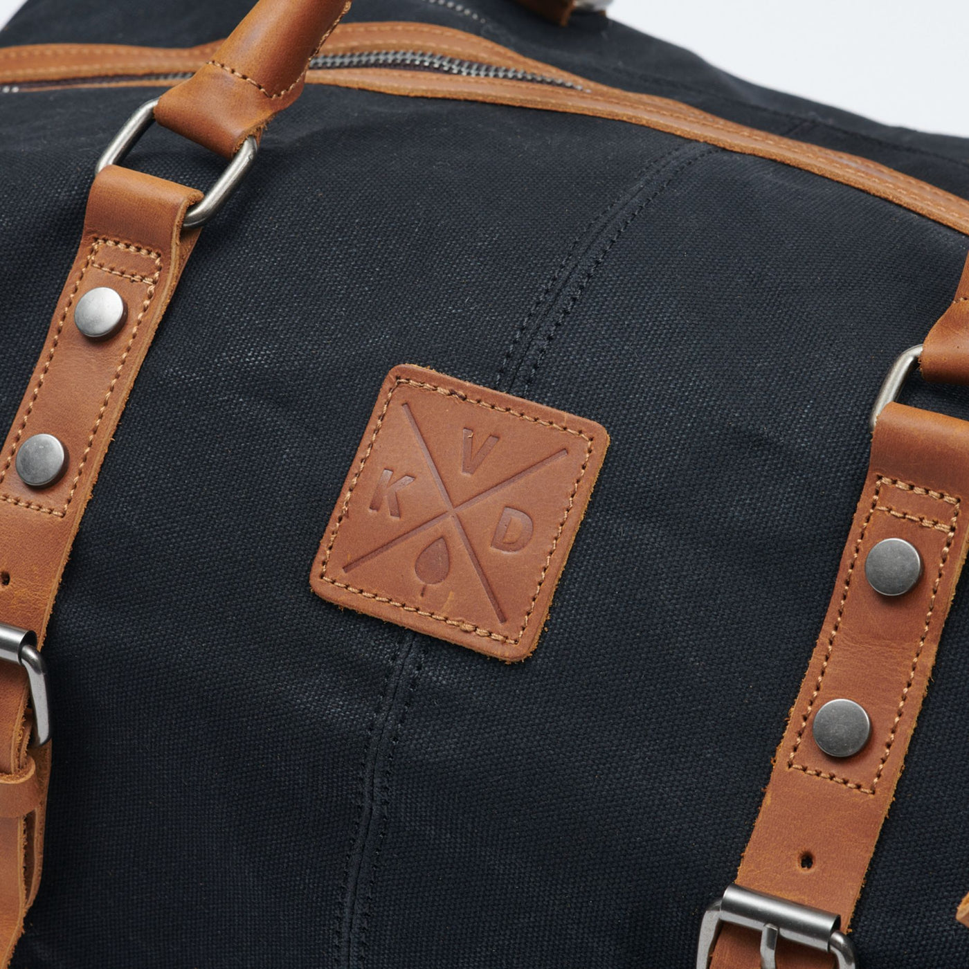 Kovered logo detail on Humber holdall made from waxed canvas and reclaimed leather#colour_black