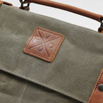 Kovered Mersey moss green messenger style laptop bag close up of logo#colour_moss-green