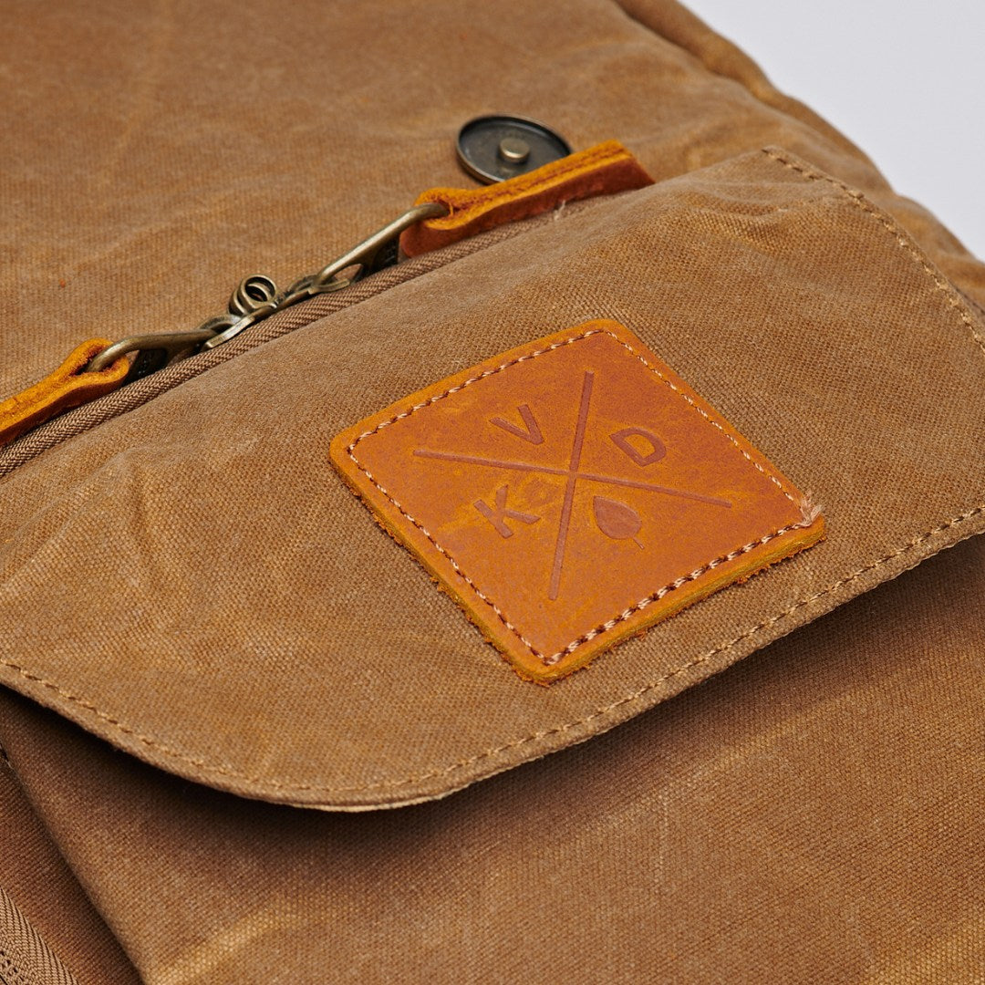 Kovered Roe adventure backpack tan close up of KVD logo detail and lockable zips#colour_tan