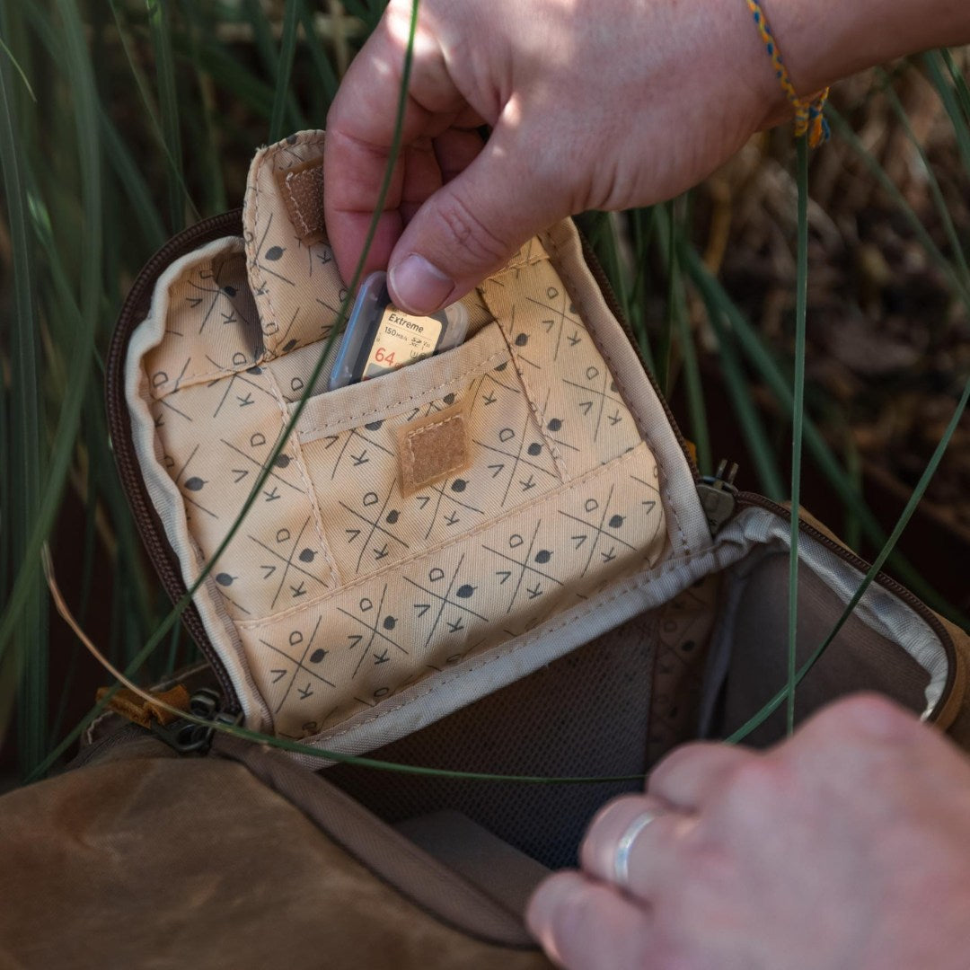 Kovered Roe tan camera backpack close up of memory card being taken out of designated pocket#colour_tan