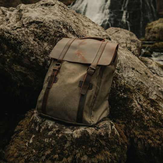 Kovered Tamar moss green canvas backpack in front of waterfall#colour_moss-green