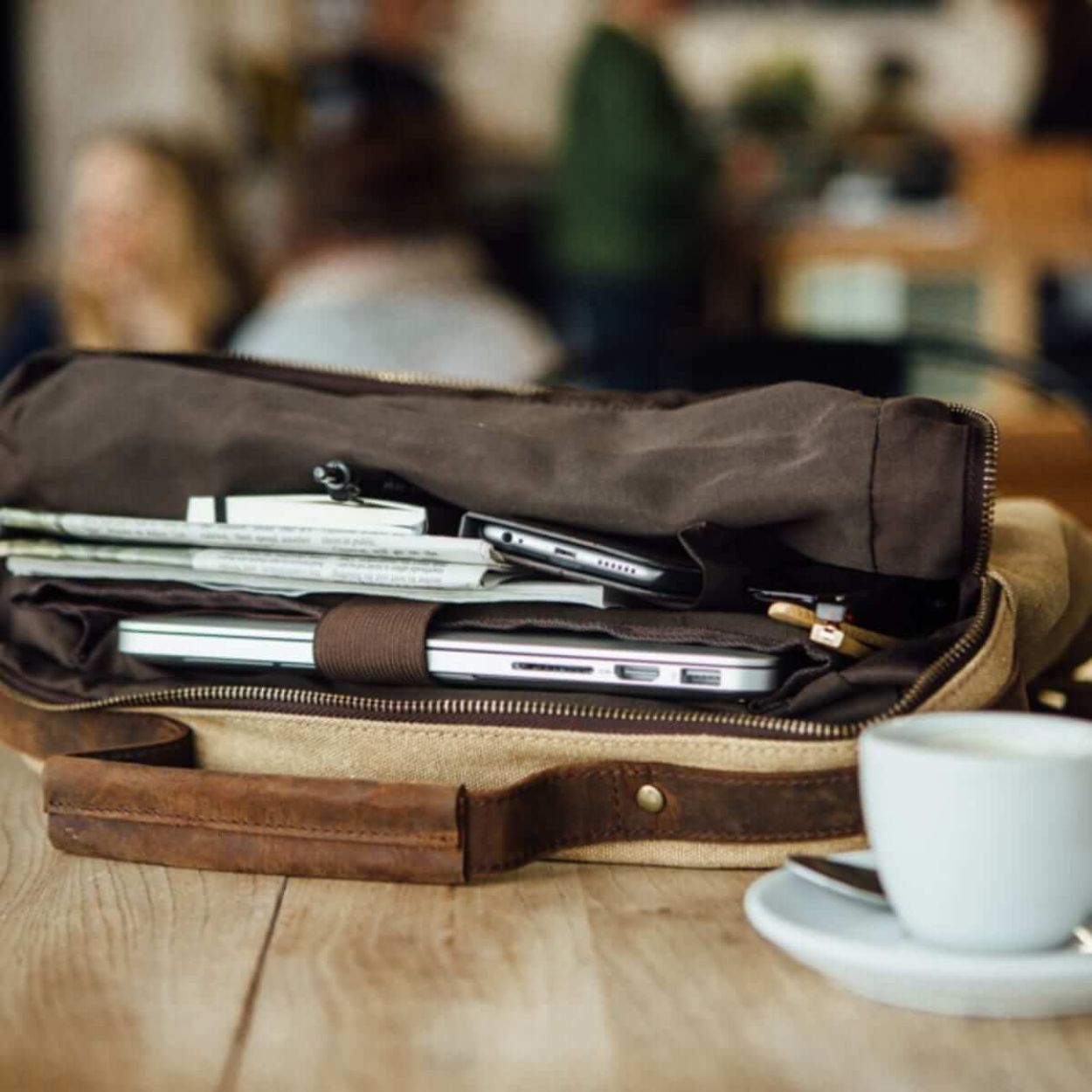 Kovered Tamar tan backpack on coffee table with laptop and belongings inside#colour_tan