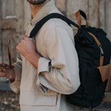 Man wearing the Tay canvas backpack over one shoulder