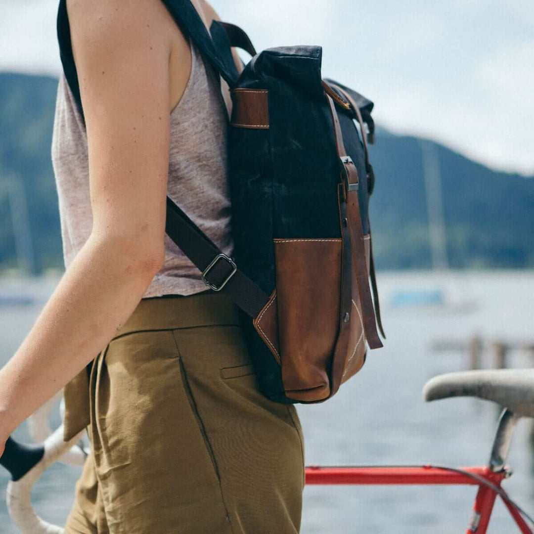 Kovered sustainable waxed canvas and reclaimed leather black backpack on model#colour_black