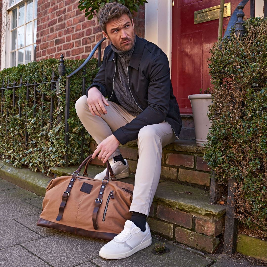 Torridge brown holdall duffle bag next to model#colour_brown