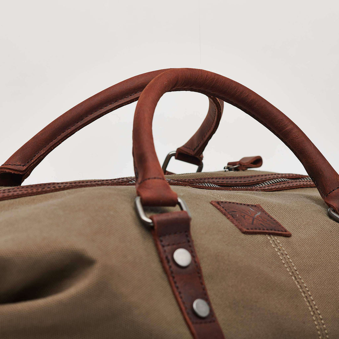 Torridge moss green holdall close up of sustainably made reclaimed leather carry handles#colour_moss-green