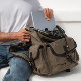 Man using the laptop pocket in the Lune canvas backpack