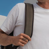 Close up image of the Lune backpack strap over a mans shoulder.