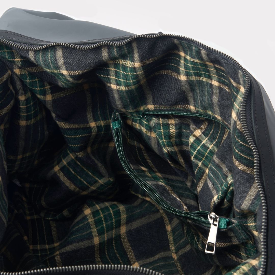 Close-up of a plaid fabric interior with a zipper, likely from a garment or bag.