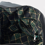 Close-up of a plaid fabric interior with a zipper, likely from a garment or bag.