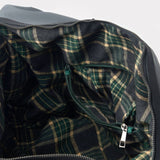 Close-up of a plaid fabric interior with a zipper, likely from a garment or bag.