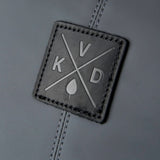 Square leather patch with 'KVD' logo on a gray background
