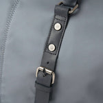 Close-up of a gray leather strap with metal buckles on a gray background