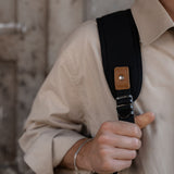 Padded backpack strap on the Tay rolltop black canvas backpack