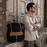 Man stood next to the Tay canvas and reclaimed leather backpack 