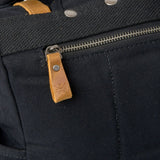 Kovered branded leather zip pull on the waxed canvas Tay rolltop backpack.