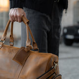 Man carrying tan leather winster holdall with carry handles