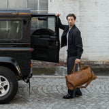 Man carrying tan reclaimed leather holdall