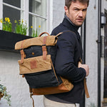 Kovered black and tan rolltop waxed canvas rolltop backpack on model#colour_black