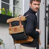 Kovered black and tan rolltop waxed canvas rolltop backpack on model#colour_black