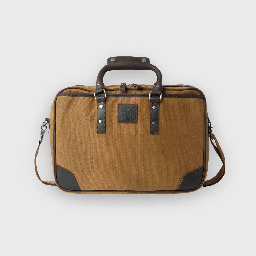 Brown travel bag with leather accents on a light gray background
