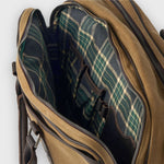 Brown leather bag with plaid interior on a white background