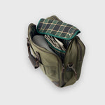 Green leather bag with plaid lining on a light gray background